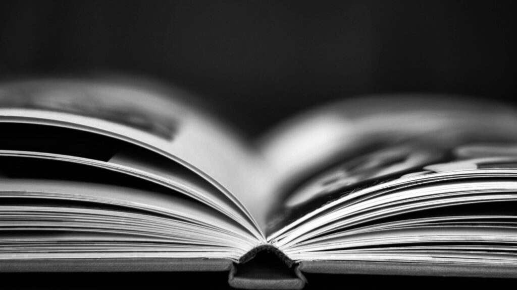 An open book displaying pages with text and images in a blurred background.